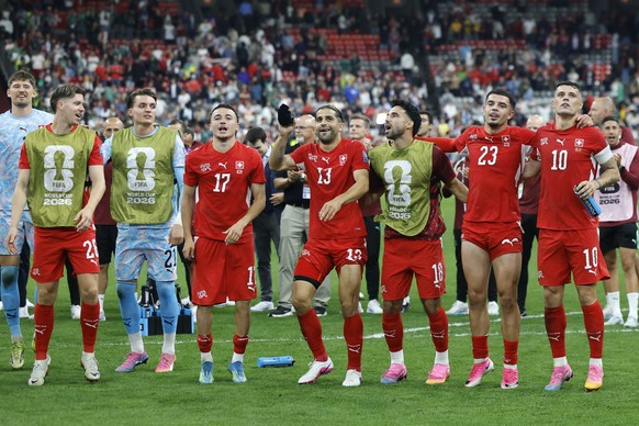 Switzerland's Granit Xhaka, Zeki Amdouni, Eray Comert, Ricardo Rodriguez, Ruben Vargas, Marvin Keller, Cedric Itten and Gregor Kobel, from right, celebrate their victory after the World Cup round ...