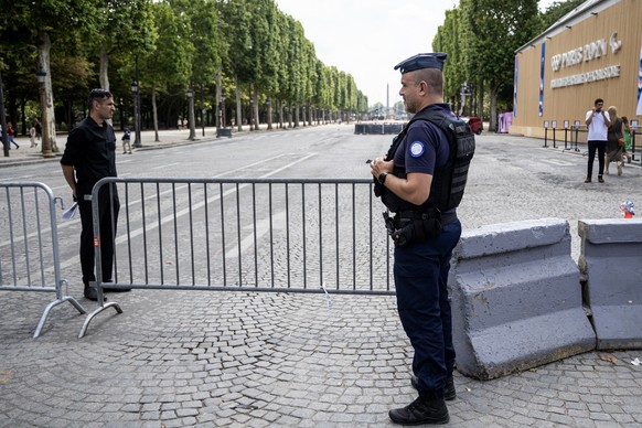 epa11441029 French police officers secure a perimeter around the Paris 2024 official store on the Champs-Elysees on its opening day in Paris, France, 27 June 2024. The Paris 2024 store on Champs-Elyse ...