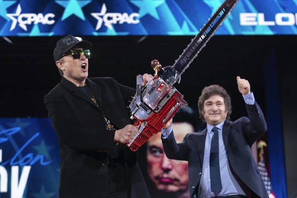 Elon Musk, left, receives a chainsaw from Argentina&#039;s President Javier Milei as they arrive speaks at the Conservative Political Action Conference, CPAC, at the Gaylord National Resort &amp; Conv ...