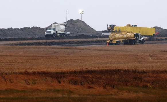 FILE - This Oct. 11, 2013, file photo shows cleanup at the site of a Tesoro Corp. pipeline break that spilled more than 20,000 barrels of oil into a Tioga, N.D., wheat field. Nearly five years after a ...