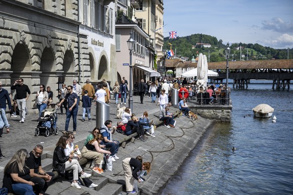 Die Menschen geniessen den warmen Fruehlingstag an der reuss in der Altstadt von Luzern am Samstag, 4. Mai 2024. (KEYSTONE/Urs Flueeler).