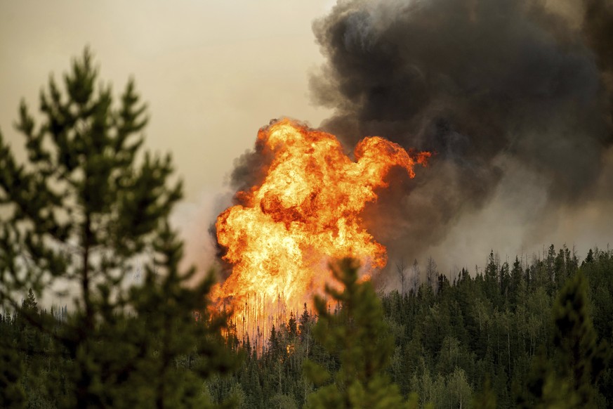 Flames from the Donnie Creek wildfire burn along a ridge top north of Fort St. John, British Columbia, Canada, Sunday, July 2, 2023. (AP Photo/Noah Berger)