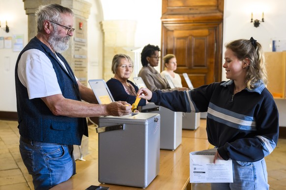 A woman casts her ballot during Swiss federal elections in Delemont, Switzerland, Sunday, October 22, 2023. Swiss citizens will elect a new parliament. The Swiss voters elect their political represent ...