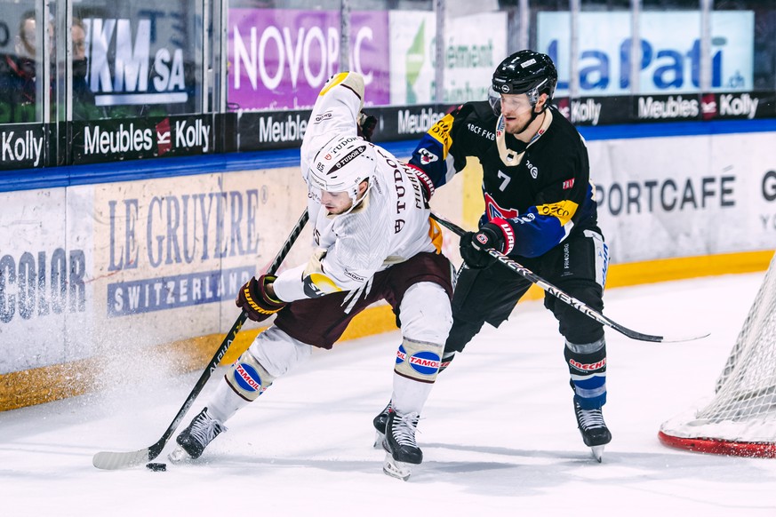 L?attaquant genevois Marco Miranda, gauche, lutte pour le puck avec le defenseur fribourgeois Benoit Jecker, droite, lors du match du championnat suisse de hockey sur glace de National League entre le ...