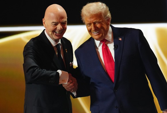 President Donald Trump is greeted by FIFA President Gianni Infantino during the draw for the 2026 soccer World Cup at the Kennedy Center in Washington, Friday, Dec. 5, 2025. (Jia Haocheng/Pool Photo v ...