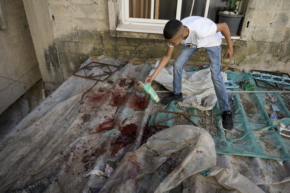 A boy looks at blood stains after a military raid in the Nur Shams refugee camp near the city of Tulkarem, in the occupied West Bank Saturday, May 6, 2023. Israeli forces shot dead two Palestinians du ...