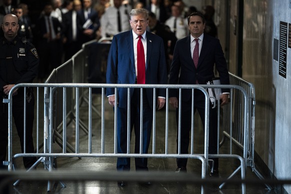 epa11280197 Former US President Donald Trump (C) speaks to the press as he arrives at Manhattan criminal court with his legal team ahead of the start of jury selection on the first day of his hush mon ...