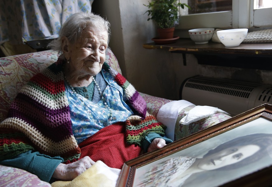 In this Friday, June 26, 2015 photo, Emma Morano, 115, looks at an old portrait of herself in her apartment in Verbania, Italy. Morano and Susannah Mushatt Jones, also 115, of the Brooklyn borough of  ...