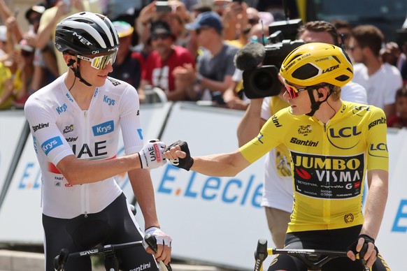 epa10733902 White Jersey best young rider Slovenian rider Tadej Pogacar (L) of team UAE Team Emirates bumps fists with Yellow Jersey overall leader Danish rider Jonas Vingegaard of team Jumbo-Visma on ...