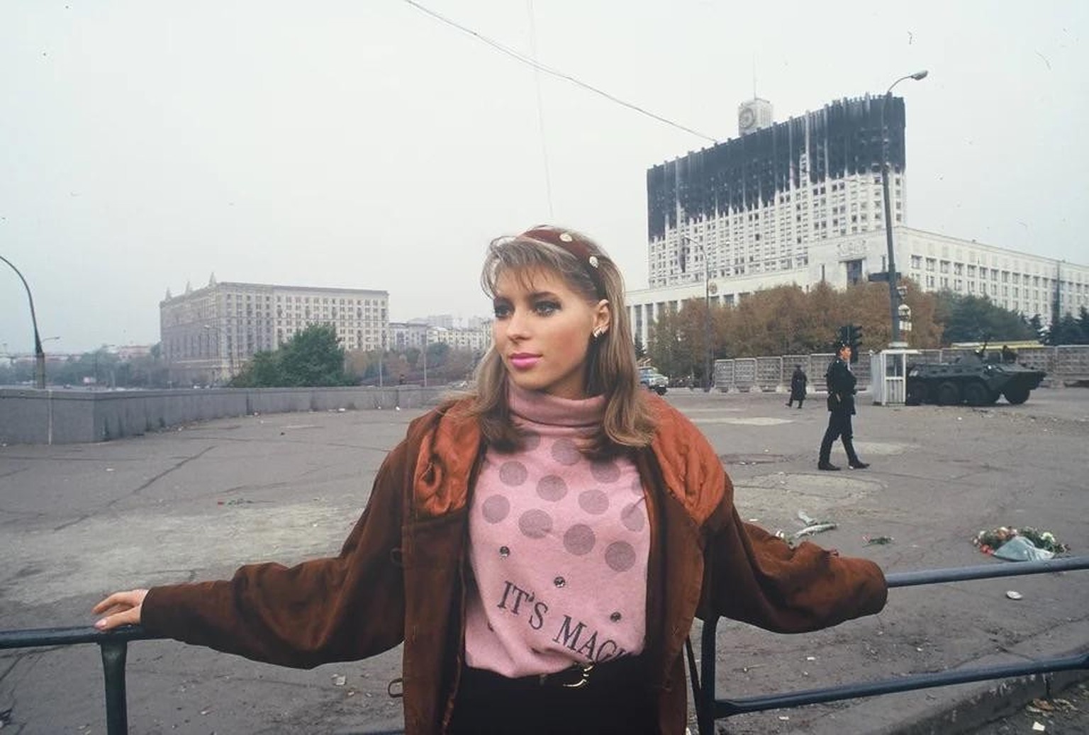 Russian woman, with the background of the burnt out Parliament building, and a BTR APC - Moscow, Russia – aftermath of the constitutional crisis, c. October 1993. Aus Adam Curtis&#039; Dokumentarfilm  ...