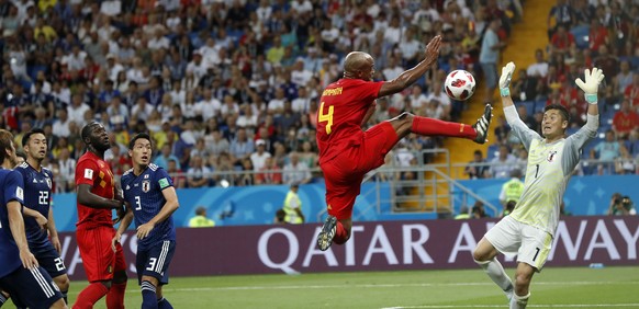Players watching Belgium&#039;s Vincent Kompany jumping with the ball in front of Japan goalkeeper Eiji Kawashima during the round of 16 match between Belgium and Japan at the 2018 soccer World Cup in ...