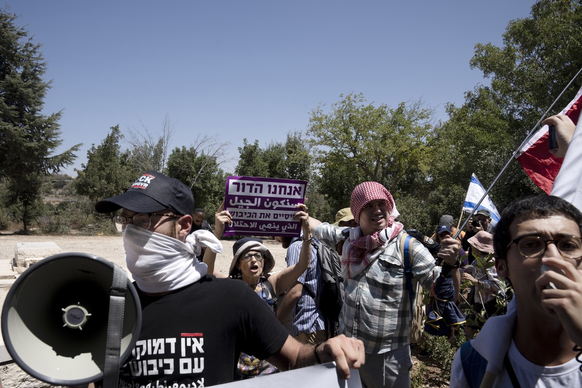 Israelis stand near the grave of Baruch Goldstein, a Jewish extremist who massacred 29 Muslim worshippers at Hebron's Ibrahimi Mosque in 1994, protest near the home of far-right National Security ...