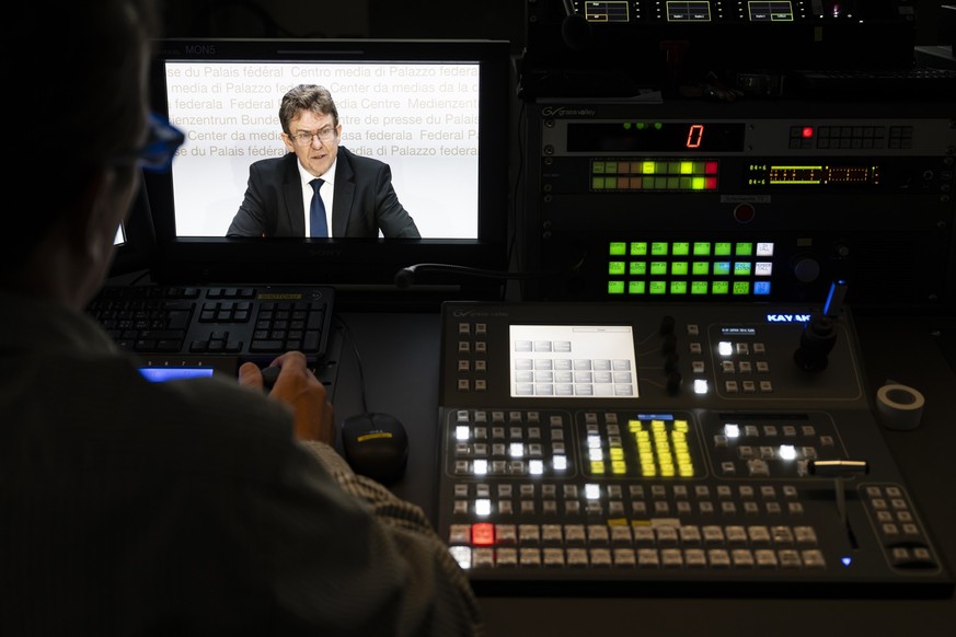 Bundesrat Albert Roesti, erscheint auf Bildschirmen im Regieraum des Schweizer Fernsehens SRF, an einer Medienkonferenz ueber die Eidgenoessische Volksinitiative "200 Franken sind genug! (SRG-Ini ...