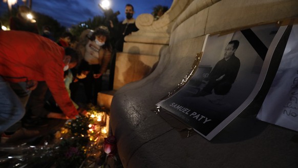 epa08763018 People light candles during a national day of remembrance for the late teacher Samuel Paty on the Promenade des Anglais in Nice, France, October 21, 2020. French history teacher Samuel Paty was...