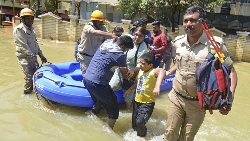 Firefighters help evacuate residents from a flooded area after heavy rainfall in Bangalore, India, Monday, Sept. 5, 2022. Life for many in the southern Indian city of Bengaluru was disrupted on Tuesda ...
