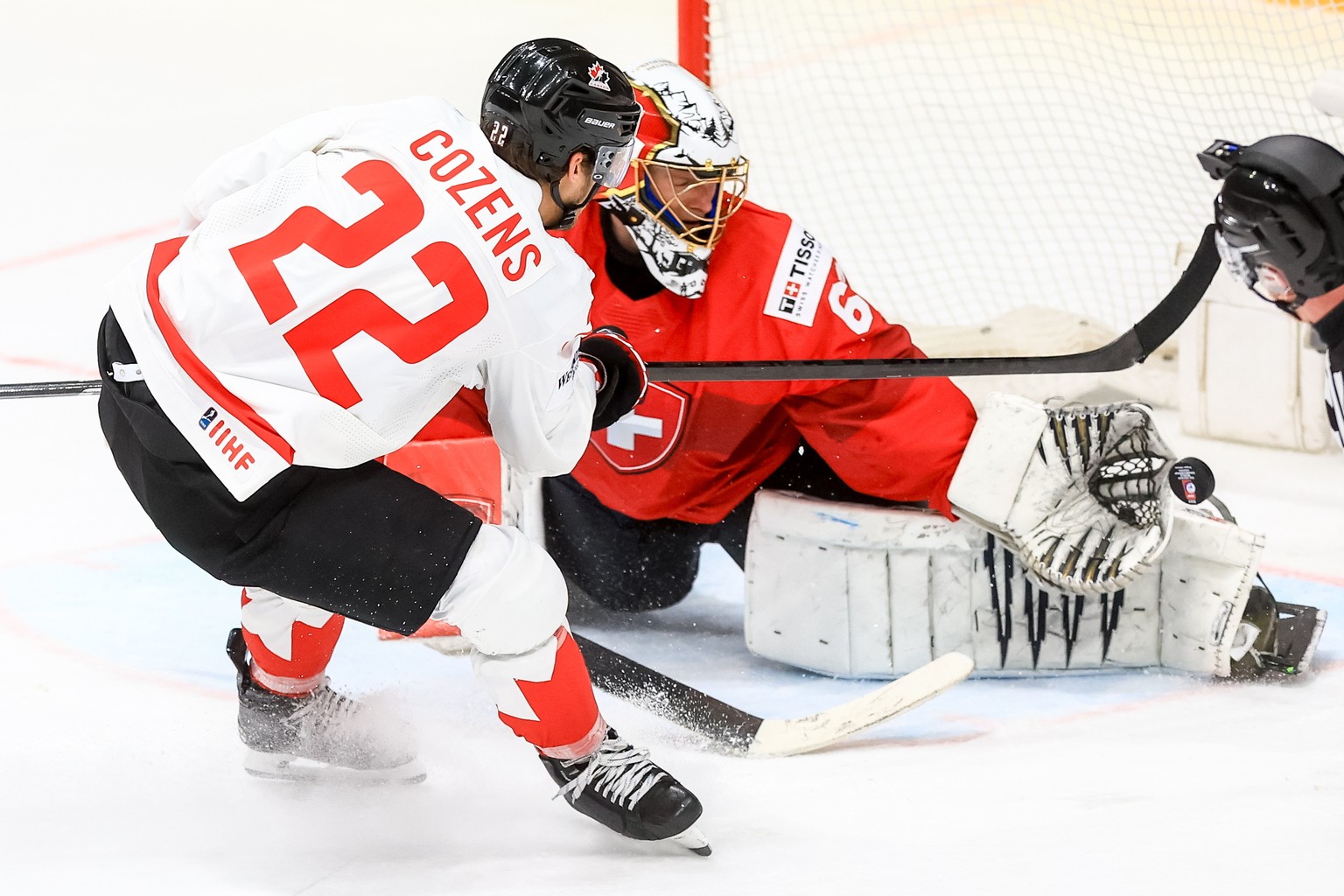 epaselect epa11369778 Dylan Cozens of Canada (L) in action against goalkeeper Leonardo Genoni of Switzerland (R) during the semi final match between Canada and Switzerland at the IIHF Ice Hockey World ...
