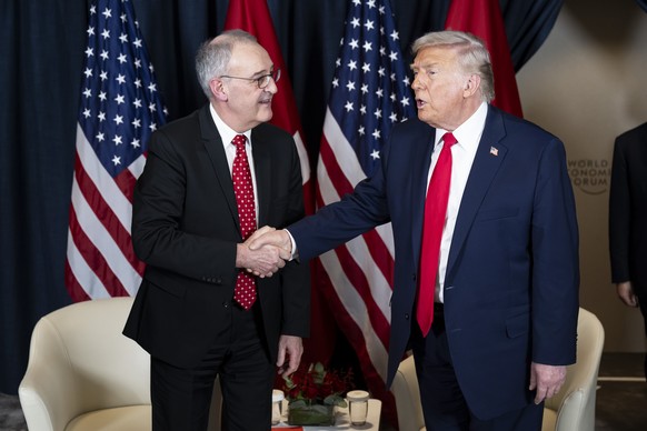 Switzerland's Federal President Guy Parmelin, left, and US President Donald Trump, right, shakes hands prior to a bilateral meeting in Congress Centre on the sideline of the 56th annual meeting o ...