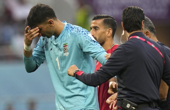 Iran&#039;s goalkeeper Alireza Beiranvand is attended by team support staff after he was injured during the World Cup group B soccer match between England and Iran at the Khalifa International Stadium ...