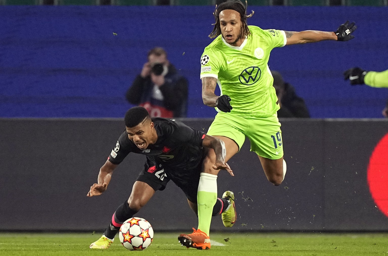 Wolfsburg&#039;s Kevin Mbabu, right, challenges for the ball with Lille&#039;s Reinildo Mandava, left, during the Champions League group G soccer match between VfL Wolfsburg and Lille OSC in Wolfsburg ...