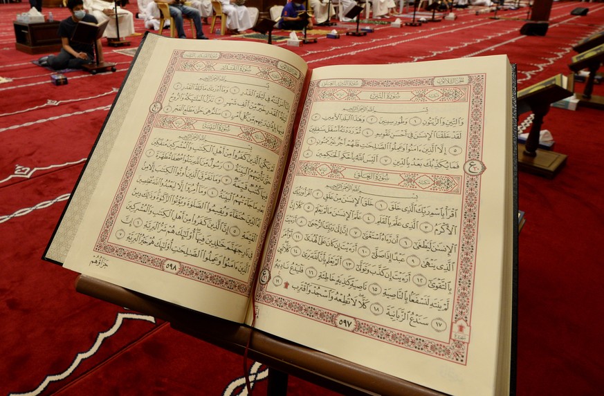 epa09186678 A Muslim worshipper reads the Holy Koran on Laylat al-Qadr at Mosque in Kuwait City, Kuwait, 08 May 2021. Muslims around the world celebrate the holy month of Ramadan by praying during the ...