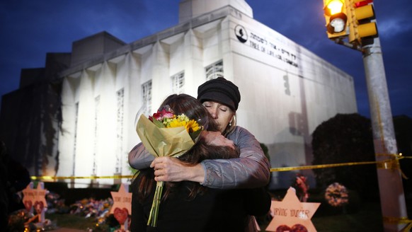 BILDPAKET -- ZUM JAHRESRUECKBLICK 2018 OKTOBER, STELLEN WIR IHNEN HEUTE FOLGENDES BILDMATERIAL ZUR VERFUEGUNG -- epa07130276 Two women hug before placing flowers at the Star of David memorials in fron ...