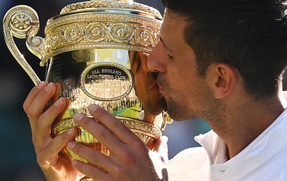 epaselect epa10064042 Novak Djokovic of Serbia kisses the trophy after winning the men's final match against Nick Kyrgios of Australia at the Wimbledon Championships, in Wimbledon, Britain, 10 Ju ...