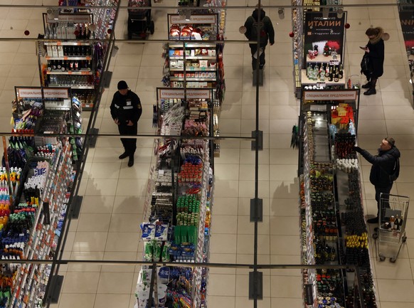 MOSCOW, RUSSIA - DECEMBER,23: (RUSSIA OUT) Shoppers and security guard look at the grocery shelves within the Miratorg supermarket, December 23, 2022, in Moscow, Russia. The Russian ruble has fallen t ...