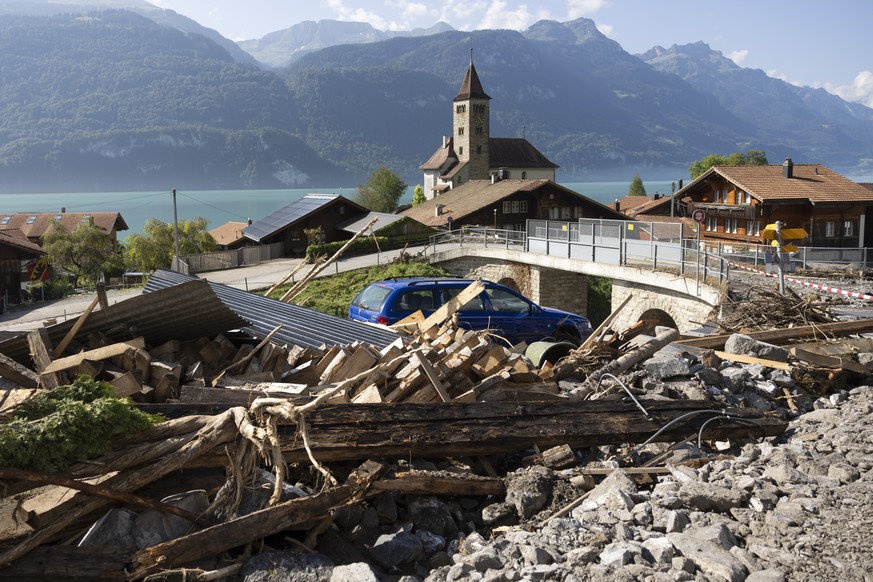 Felsbloecke, Steine und Holz von einer Geroelllawine liegen zwischen den Haeusern, am Freitag, 16. August 2024 in Brienz im Berner Oberland. Am Montag Abend haben heftige Gewitter einen Murgang ausgel ...