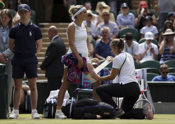 Switzerland&#039;s Timea Bacsinszky receives treatment during a medical timeout in the Women&#039;s Singles Match against Poland&#039;s Agnieszka Radwanska on day six at the Wimbledon Tennis Champions ...