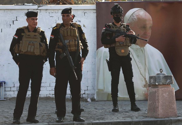 epa09053951 Security keep watch as a motorcade carrying Pope Francis arrives at Our Lady of Delivrance church, in Baghdad, Iraq, 05 March 2021. Pope Francis started his three-day official visit to Ira ...