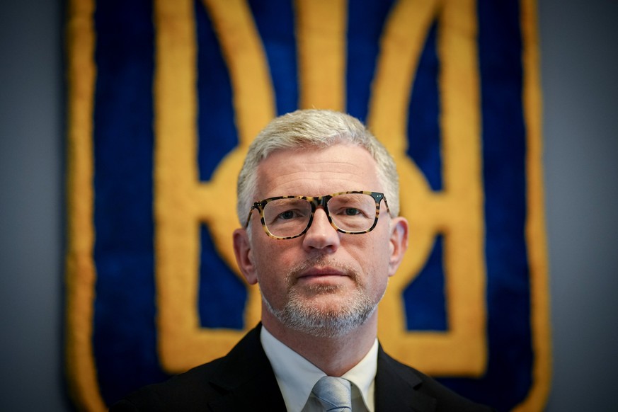 ARCHIV - 27.04.2022, Berlin: Andrij Melnyk, Botschafter der Ukraine in Deutschland, blickt vor dem Wappen der Ukraine im Botschaftsgeb