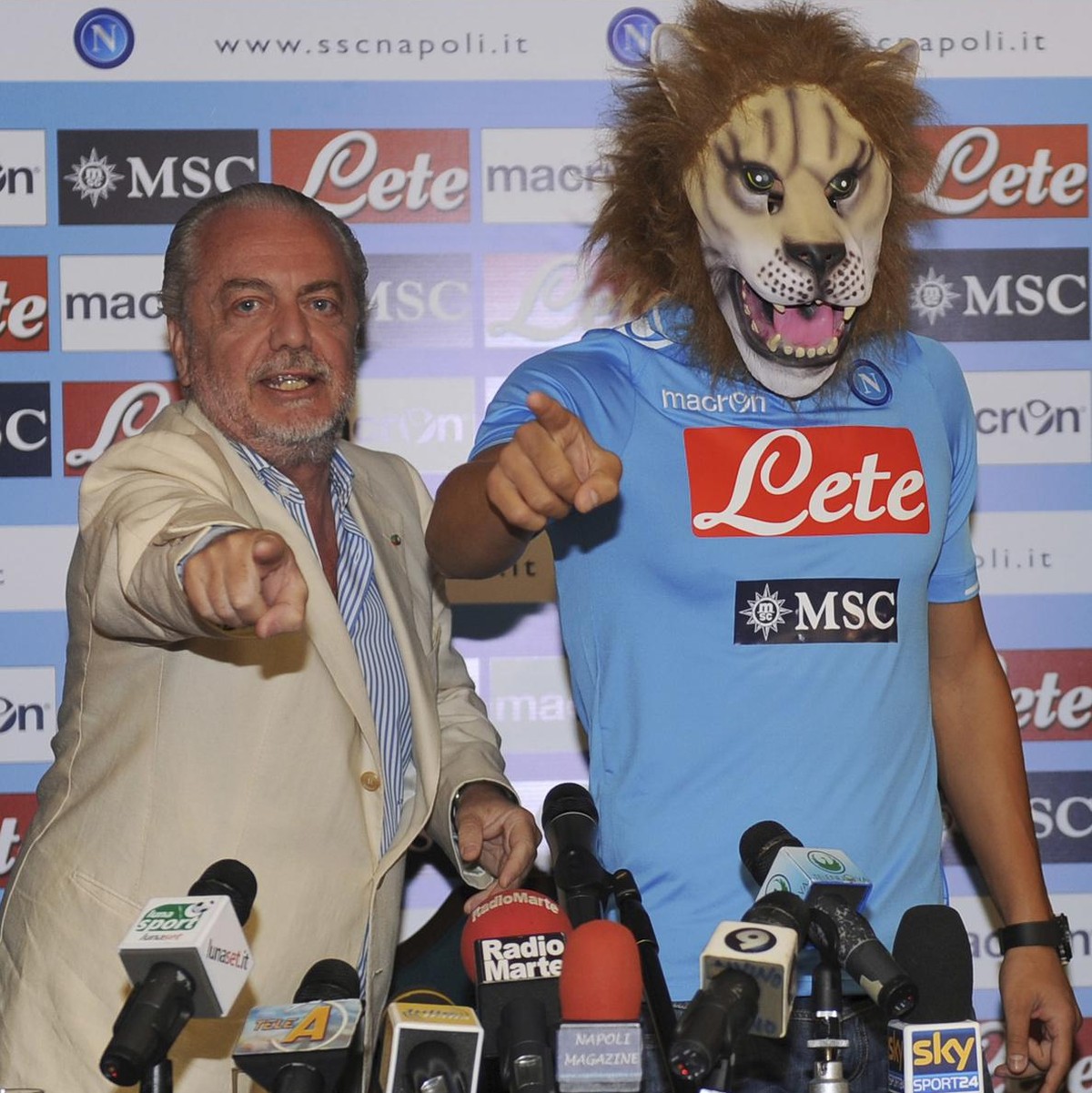 Swiss soccer player Goekhan Inler, right, wears a lion mask as a surprise for his supporters,while posing with Napoli's president Aurelio de Laurentiis, during his official presentation, in Naple ...