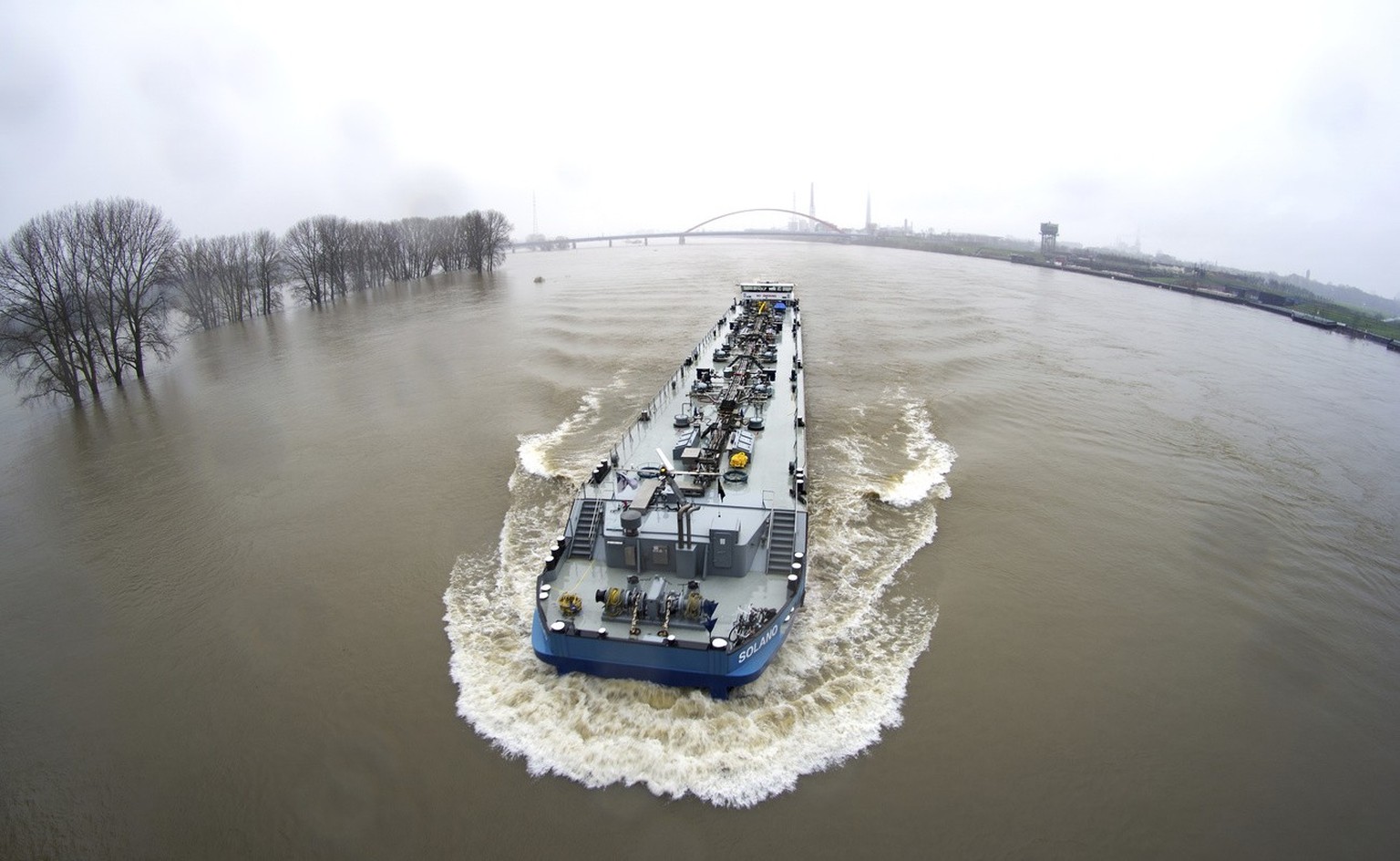 The river Rhine floods as a vessel drives past the city of Duisburg, Germany, Monday, Dec. 25, 2023. The water levels on the Lower Rhine continue to rise. (AP Photo/Michael Sohn)
