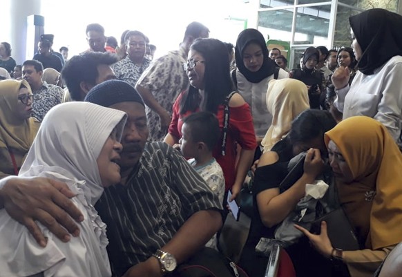 Relatives of passengers comfort each other as they wait for news on a Lion Air plane that crashed off Java Island at Depati Amir Airport in Pangkal Pinang, Indonesia Monday, Oct. 29, 2018. Indonesia d ...