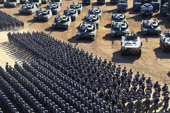 In this photo released by China&#039;s Xinhua News Agency, Chinese People&#039;s Liberation Army (PLA) troops march past military vehicles Sunday, July 31, 2017 as they arrive for a military parade to ...