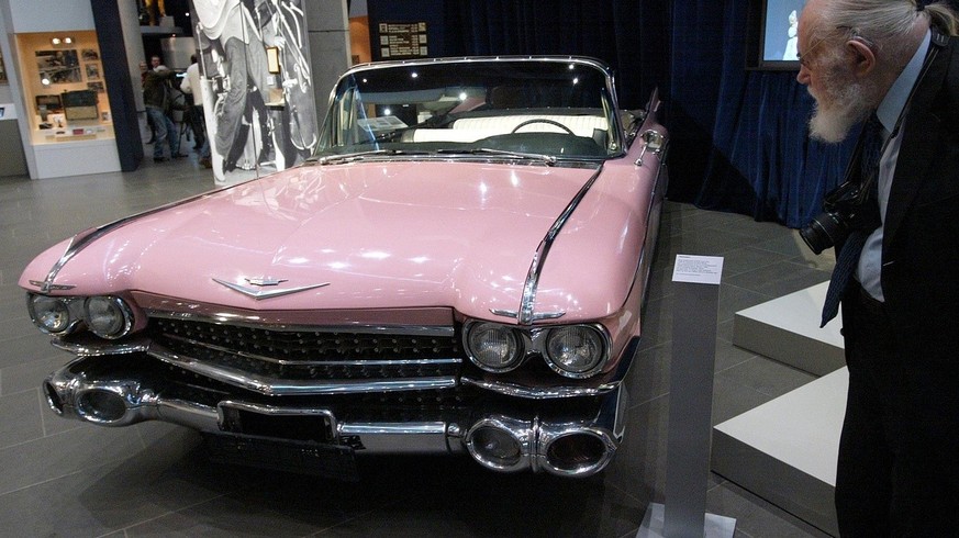 Ein Fotograf schaut am Donnerstag, 18. Nov. 2004, bei einer Pressevorbesichtigung im Haus der Geschichte in Bonn auf einen pinkfarbenen Cadillac, Baujahr 1959, der dem Rockstar Elvis Presley gehoerte. ...