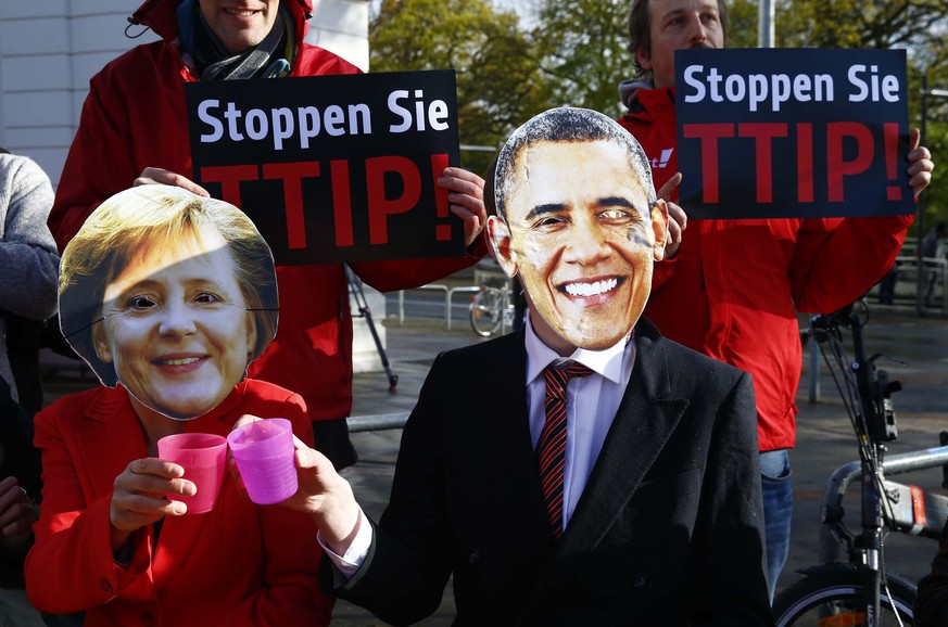 Demonstranten, die vor der Hannover Messe gegen das TTIP-Abkommen protestieren, tragen eine Merkel- bzw. Obama-Maske.&nbsp;