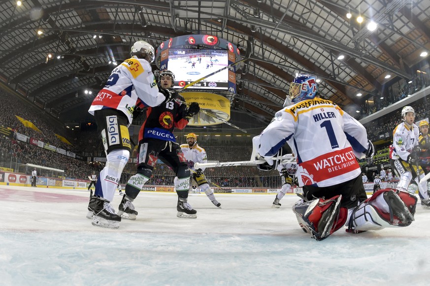 Berns Luca Hischier, Mitte, im Duell mit Biels Goalie Jonas Hiller, rechts, und Dave Sutter im ersten Eishockey Playoff-Viertelfinalspiel der National League A zwischen dem SC Bern und dem EHC Biel am ...