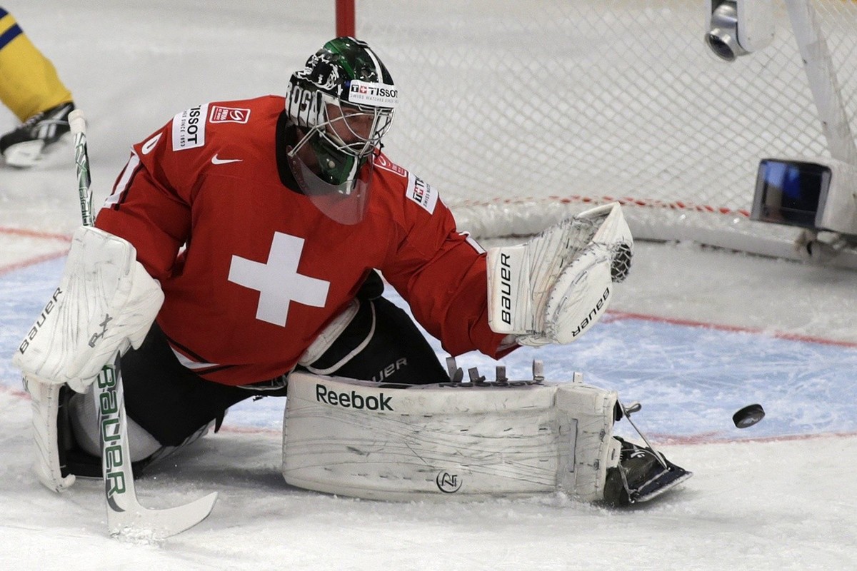 Switzerland's goaltender Martin Gerber tries to catch the puck, during the IIHF Ice Hockey World Championships preliminary round game Sweden vs Switzerland at the Globen Arena in Stockholm, Swede ...