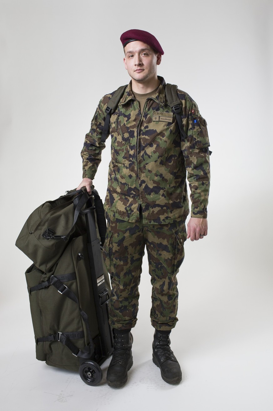 A soldier of the Swiss Armed Forces in Tenue B normal uniform with combat boots, a transport bag with a transport trolley and a belongings bag with a shoulder strap, pictured on February 12, 2014, in  ...