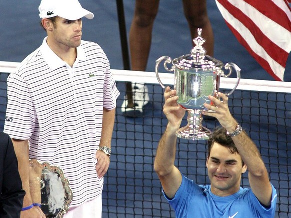 Roger Federer of Switzerland holds up the US Open Championship Trophy after defeating Andy Roddick of the US (L) to win the US Open Championship on the final day of the 2006 US Open tennis tournament in Flushing Meadows, New York Sunday 10 September 2006. (KEYSTONE/EPA/JASON SZENES)