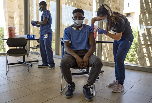 UTPB student Jaden Mitchell, center, receives his first dose of the Moderna COVID-19 vaccine from Registered Nurse Trinity Doan, right, during a vaccination clinic hosted in partnership with Midland M ...