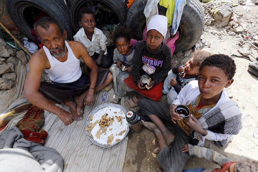 epa07467554 Displaced Yemenis share a meal inside a temporary shelter at a camp for Internally Displaced Persons (IDPs) on the outskirts of Sana&#039;a, Yemen, 27 March 2019. According to reports, the ...