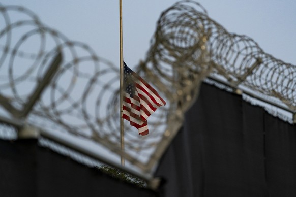 FILE - In this photo reviewed by U.S. military officials, a flag flies at half-staff in honor of the U.S. service members and other victims killed in the terrorist attack in Kabul, Afghanistan, as see ...