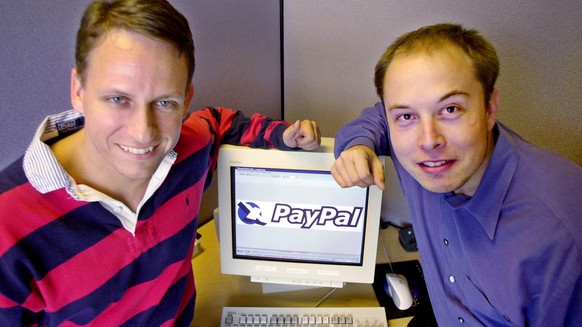 FILE--PayPal Chief Executive Officer Peter Thiel, left, and founder Elon Musk, right, pose with the PayPal logo at corporate headquarters in Palo Alto, Calif., on Oct. 20, 2000. Online auction giant e ...