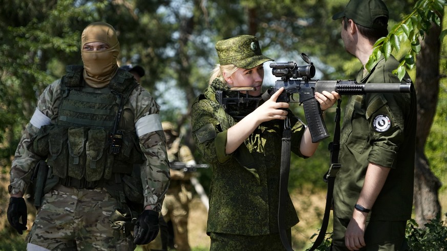 FILE - A Russian Army soldier looks through a sniper rifle scope as she and other soldiers guard a group of foreign journalists visiting a captured Ukrainian checkpoint and well-fortified trenches nea ...
