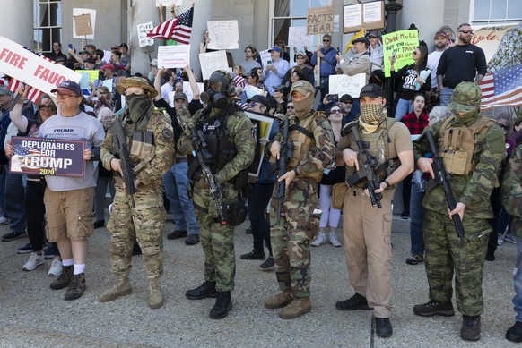 FILE - In this May 2, 2020, file photo, people, including those with the boogaloo movement, demonstrate against business closures due to concern about COVID-19, at the State House in Concord, N.H. Fac ...