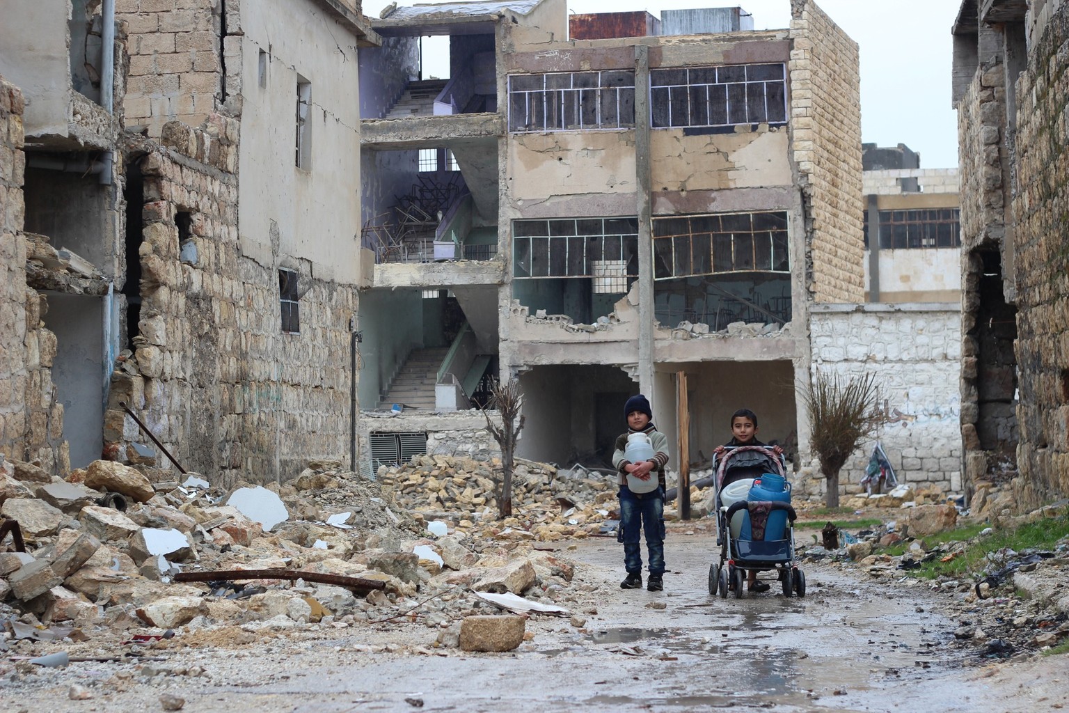 On 27 December 2016 in east Aleppo City in the Syrian Arab Republic, Hasan (right), 10, collects water for his family in Shakoor neighbourhood. Hasan and his friends try to find some fun in their dail ...