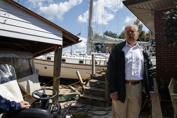 President Donald Trump visits a house where a boat wash ashore in the backyard while touring a neighborhood impacted by Hurricane Florence, Wednesday, Sept. 19, 2018, in New Bern, N.C. (AP Photo/Evan  ...