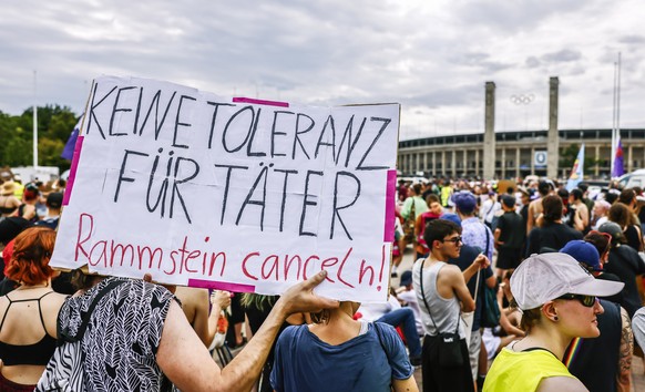 epa10748211 People protest in front of the Olympia stadium before a scheduled concert of German hard-rock band Rammstein in Berlin, Germany, 15 July 2023. Protesters are demanding the cancellations of ...